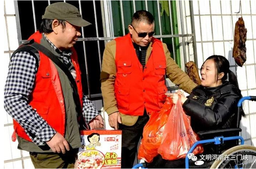 2016年，易海明（左一）到殘疾人朋友家中走訪。圖片來源：株洲文明網
