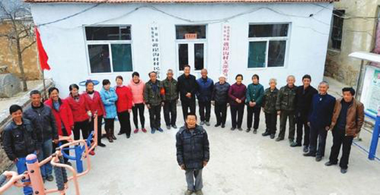 秦海松（前）與照顧他的部分村民在一起。