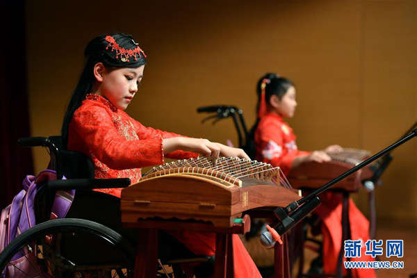 1月24日，青少年殘健融合班學員武姍姍（左）在表演古箏彈奏《漁舟唱晚》。