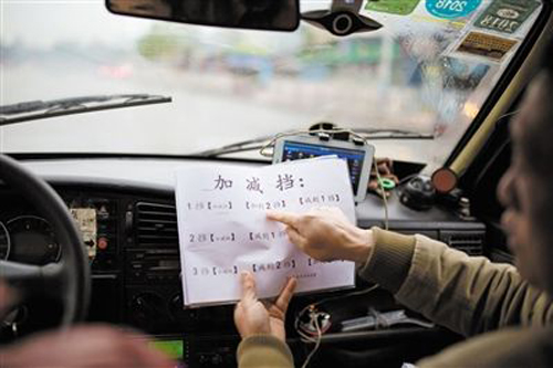 莫教練用寫字以及打手勢的方式指導聽障學生練車。